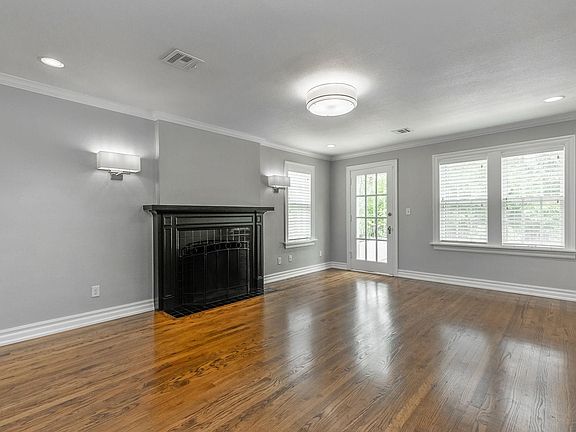 A large living area sets off the main room with natural light that brightens the room. The door leads to the outdoor sunporch.
