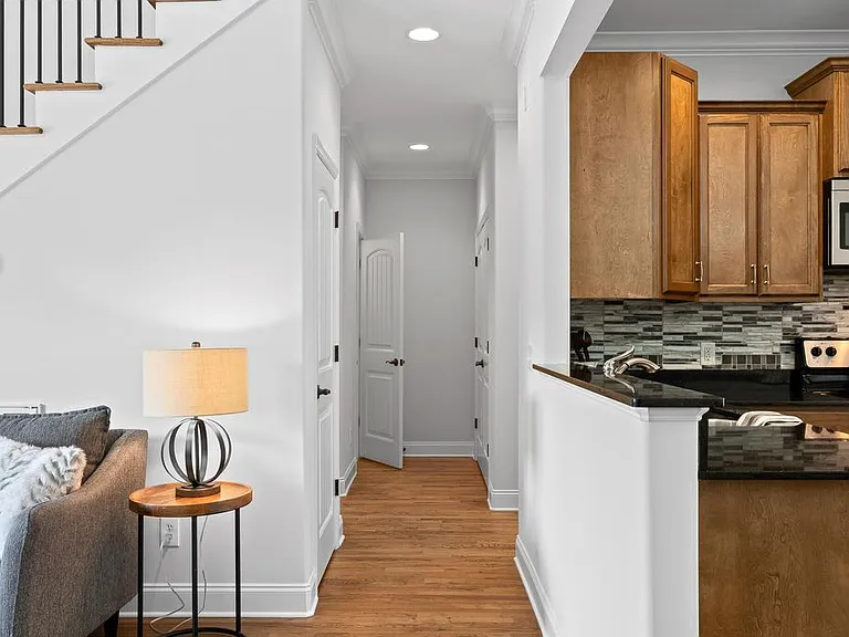 Hallway leading to half bath on lower level, Master bedroom to the right past kitchen, Laundry closet and door to the garage.