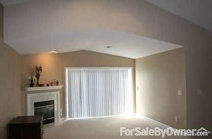 Living Room
						:
						Living room with gas fireplace and 3 panel window, vaulted ceiling.