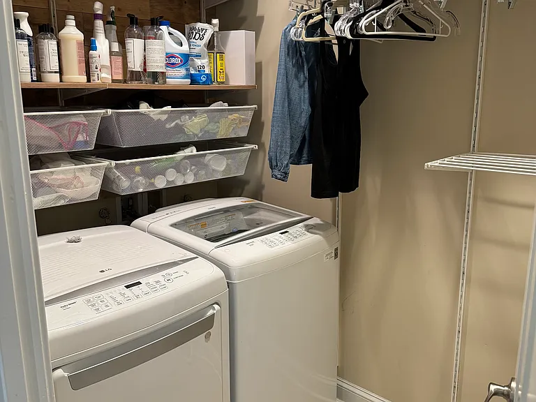 The laundry room has a washer and dryer, shelves, a drying rack, and a hanging rack. It also comes with an ironing board and iron.
