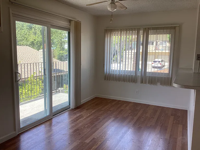 Dining area with windows and sliding glas door to balcony. Mountain views and lots of light. Ceiling fan.