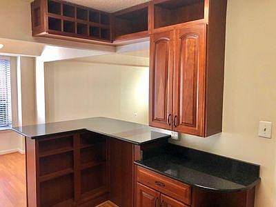 Kitchen features granite bar overlooking dining and living areas with wine rack
