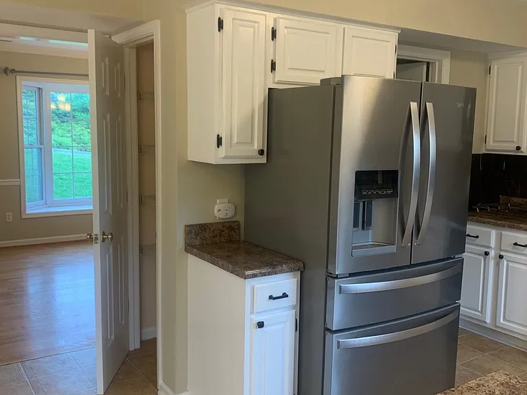 Large kitchen with electric range, oven, microwave, refrigerator, dishwasher.