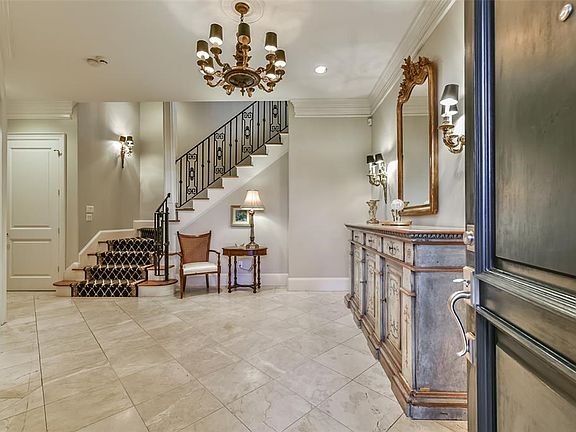 Upon entering the home, you are greeted with tile floors, high ceilings and designer lighting.  Beautiful wrought iron staircase carries throughout the home.  Elevator located to the left of the staircase.