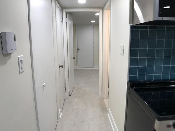 Hall towards bedroom with walk-in closet to the left and bathroom to the rigth