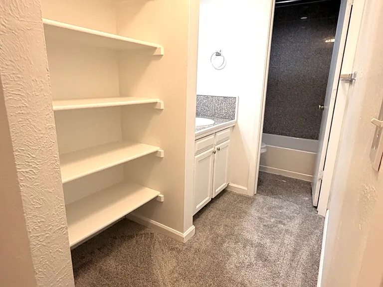 Linen shelves in front of the full bath