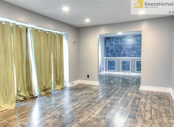 Gorgeous custom hardwoods and upgraded molding throughout this living room leading into formal dining room