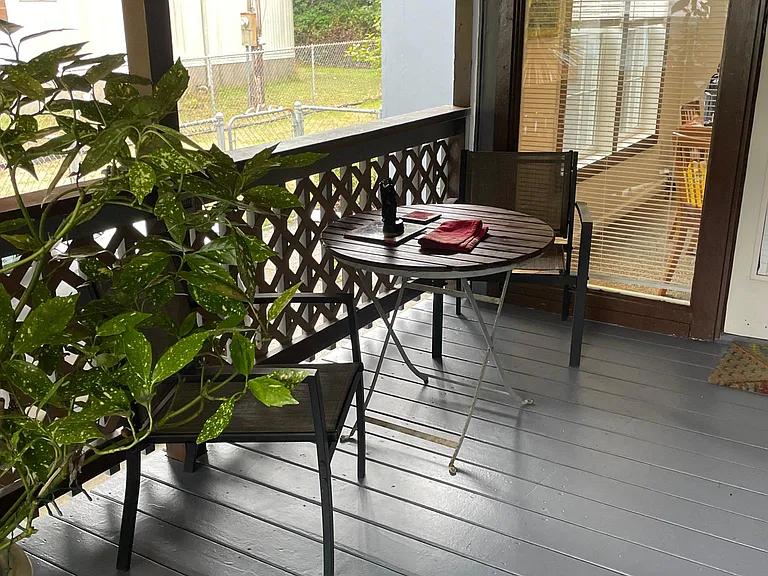 Front deck and entry to the home with a table and 2 chairs