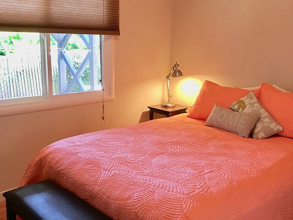 Bedroom has queen bed. There is a ceiling light and each bedside table has a reading light.