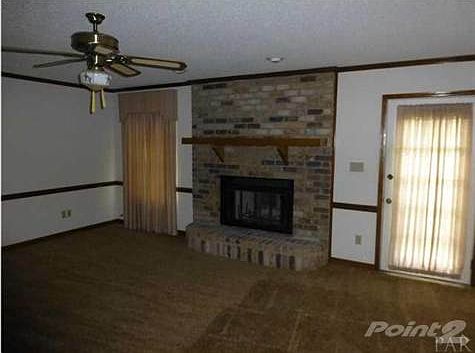 Living room with fireplace and door to concrete patio