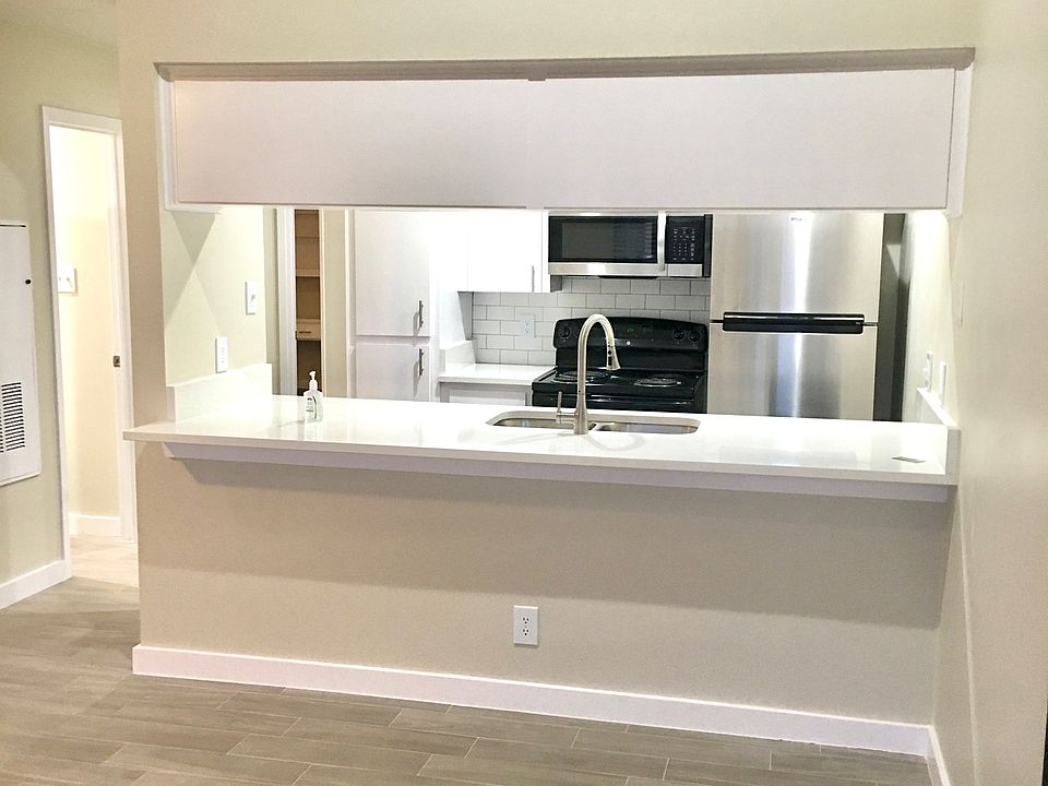 Beautiful kitchen with quartz countertop opens into dining area