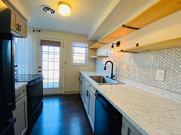 Kitchen is full of light from glass door leading to back patio.