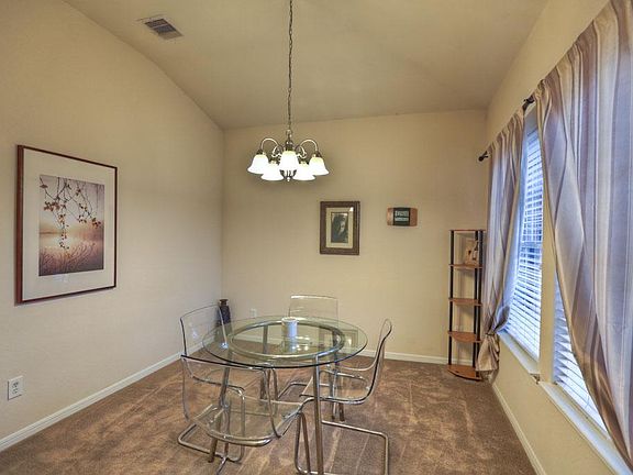 Formal dining with large picture windows with two inch blinds.