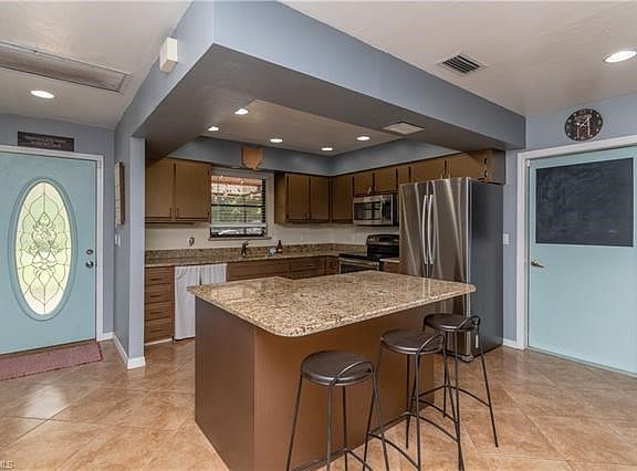 Kitchen with granite countertops and breakfast bar.
