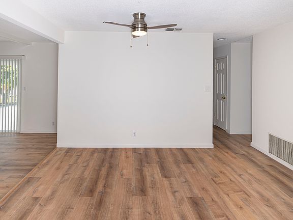 Dining area next to kitchen with overhead light and ceiling fan.