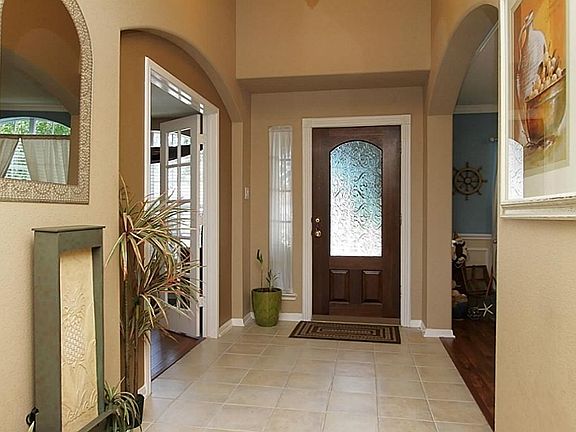 Entry has new light fixture and tile flooring leading in to den. Formal dining is on the left and a 
