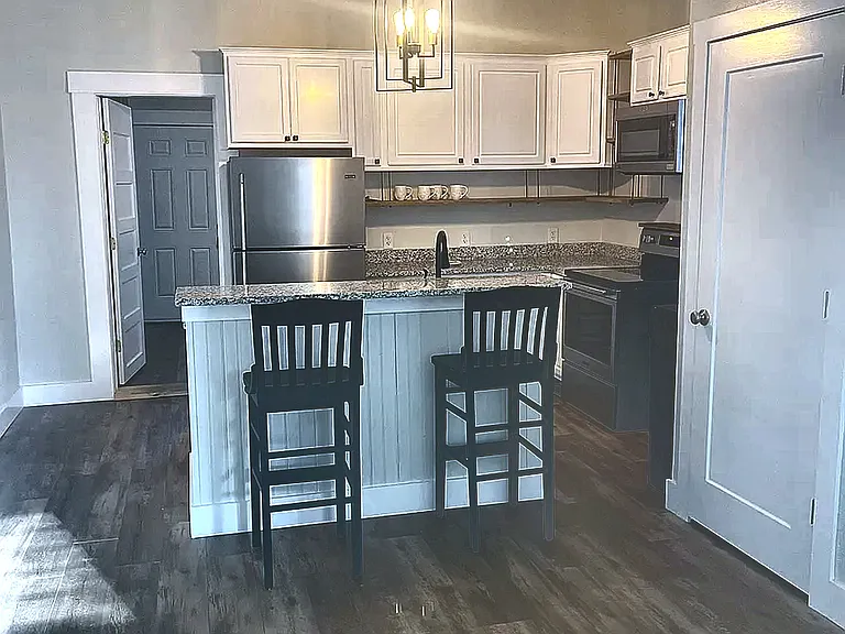 Open Kitchen and Living Area with Island Seating and Updated Finishes