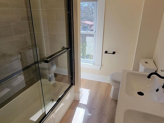 Double vanity. Black hardware. Glass shower doors.