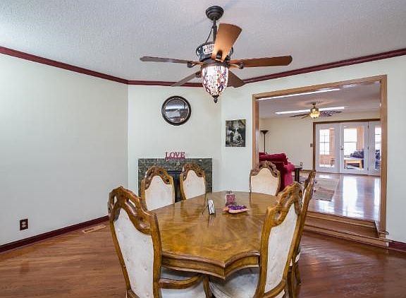 Formal dining room with fireplace. Hardwood floors and over table lighting.