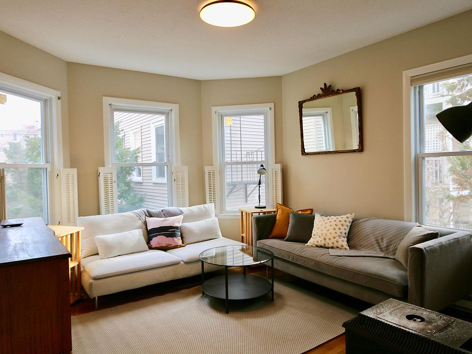 Living room has new modern furnishings and lots windows - four - including bay windows