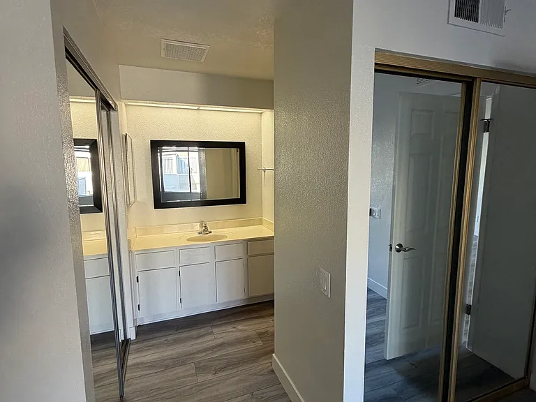 master bedroom with two closets and a vanity and bathroom attached