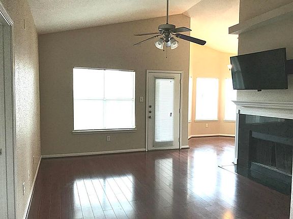 Large living space with hardwood floors and a fireplace.