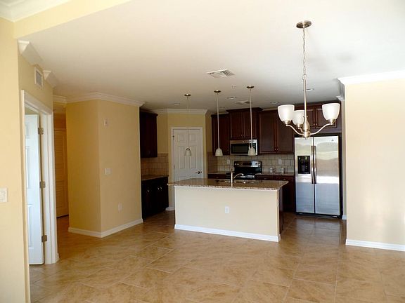 Spacious, high ceilings, crown molding, tile floor, open plan, modern cherry cabinets, granite countertops.