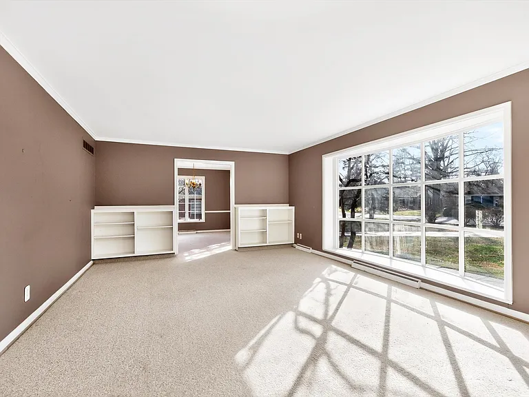 Light and bright living room with extra large window overlooking the front yard