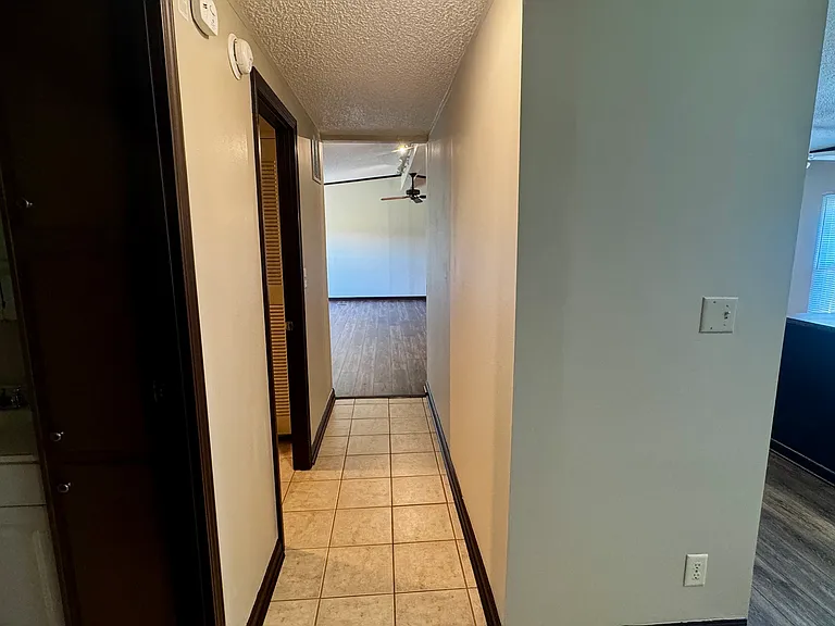 hall way from bedrooms and main bathroom and kitchen facing grate room