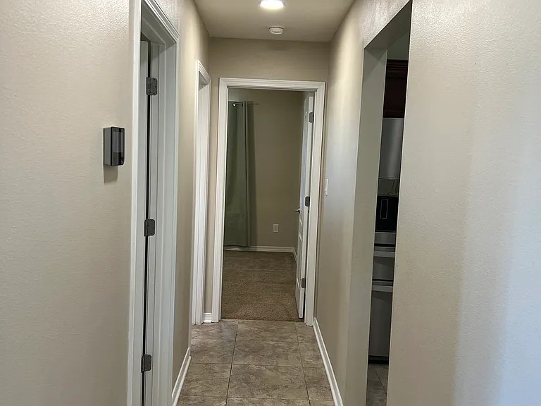 Hallway on laundry room and garage side next to kitchen for bedroom number 1 and full bathroom number 1