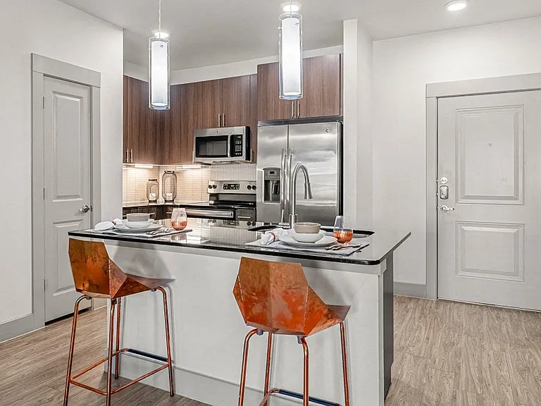 Kitchen features stainless steel, energy-efficient appliances, wood-grain cabinets and granite countertops