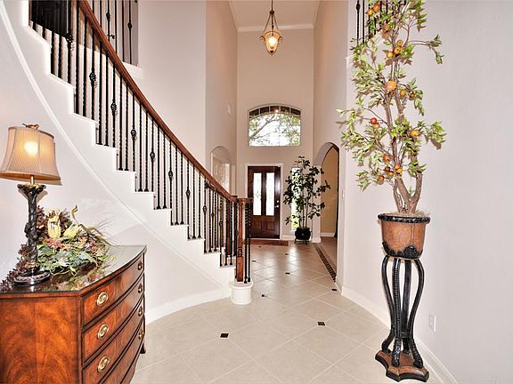Grand Entry with a Wrought-Iron Spiral Staircase and Tiled Flooring