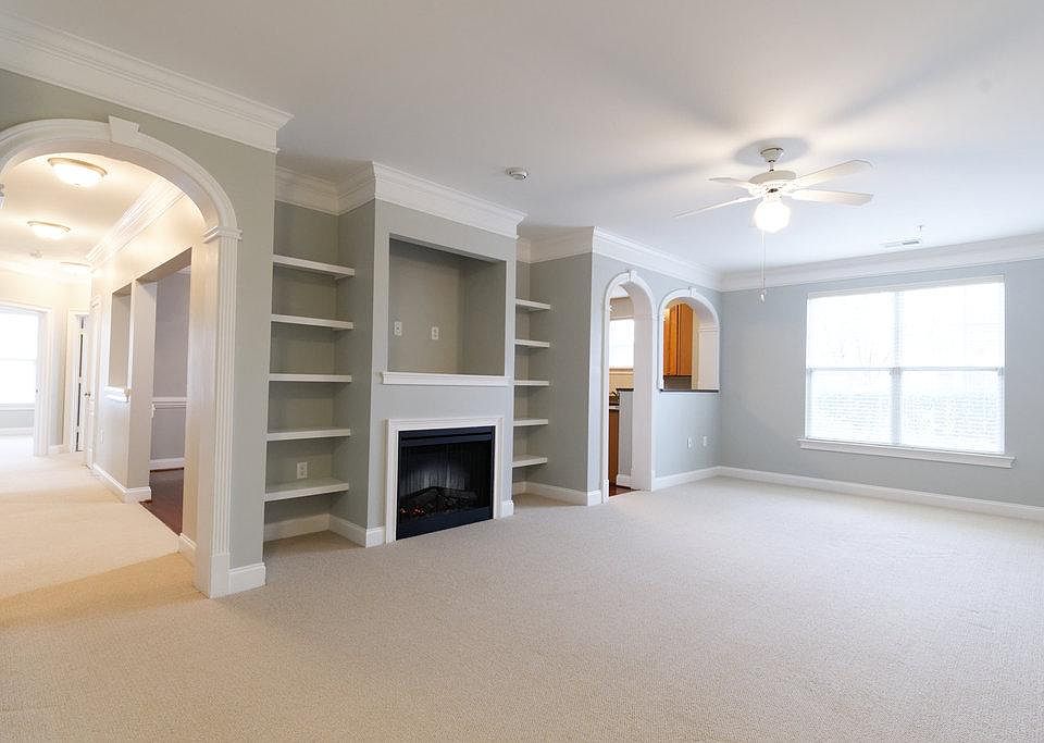 Living Room with built in bookshelves, TV nook, and electric fireplace