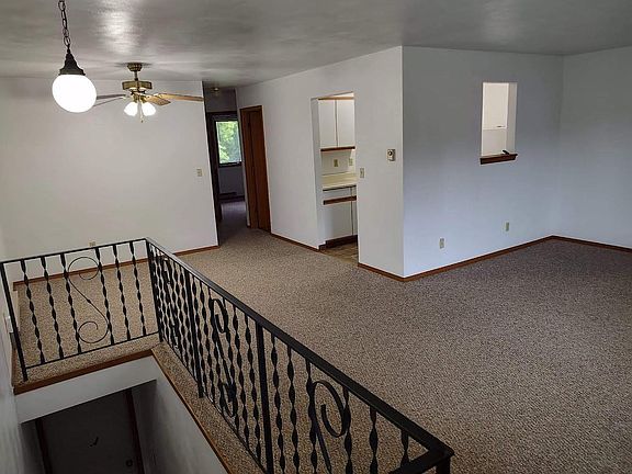 View of dining area, hallway, kitchen, living room, & staircase leading down to the garage.