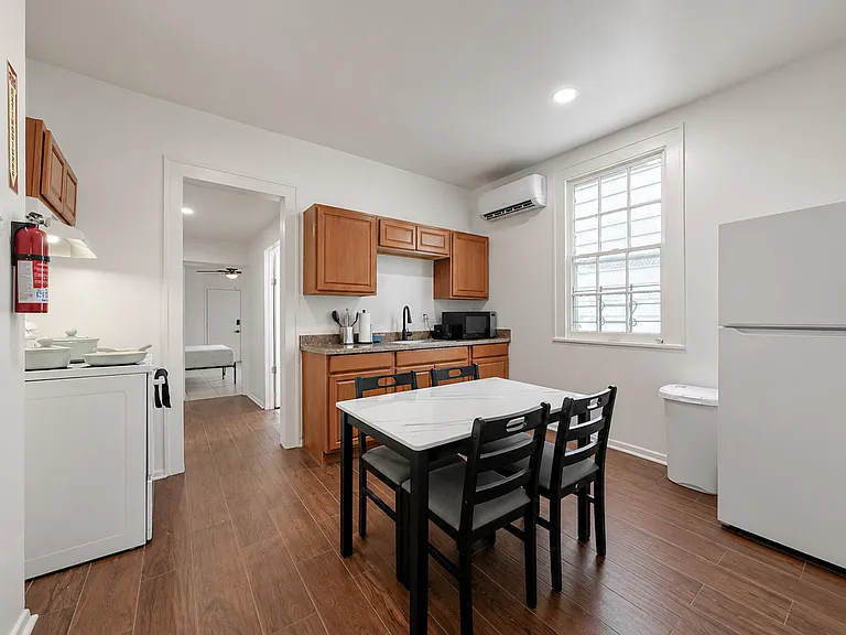 Eat-in kitchen with ample wood cabinetry, generous counter space, and room for a dining set beside a large window.