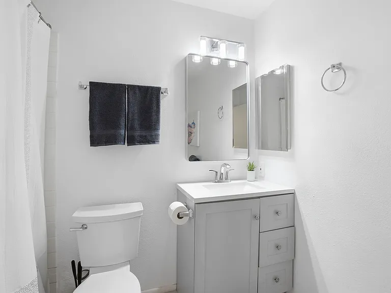Shared bathroom for Rooms 2 and 3. There is generous storage space and a tub/shower combo.