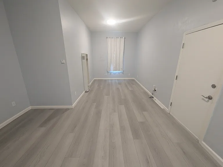 Living room and front door. Gas wall heater.