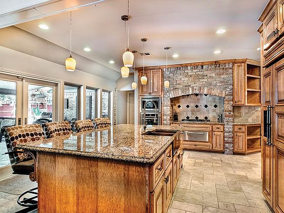 Kitchen with granite, stainless steel appliances and views to backyard is open to Den. Remodeled in 