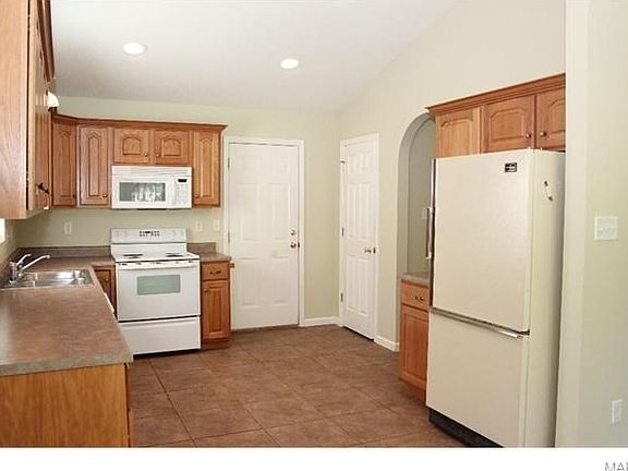 Great Kitchen! Features custom cabinets, ceramic flooring, recessed lighting with vaulted ceiling, arched doorway and opens to breakfast/dining/living area.