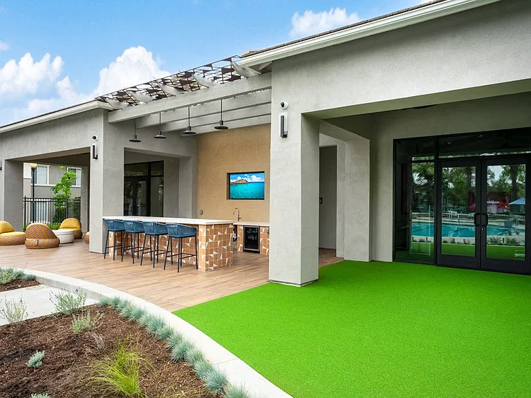 Covered Outdoor Bar with Barstool Seating, TV, and Turf Lounge Area