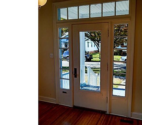 Beautiful sunny foyer with original beveled glass door and hard woods.