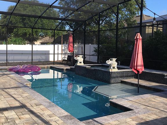 Outdoor, screened in space for entertaining. Includes; paved deck, large pool, large spa, sun shelf and fire-pit.