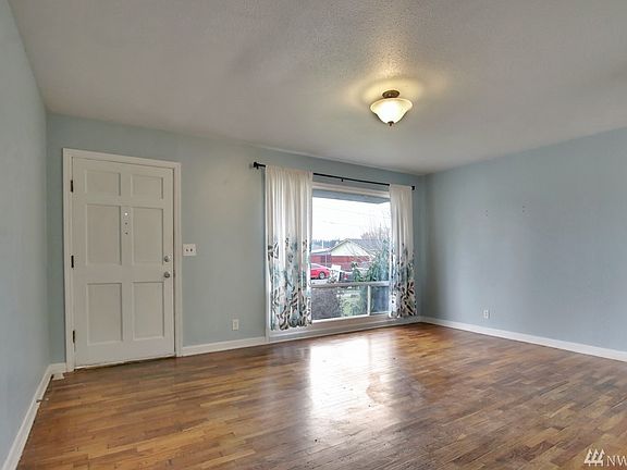 Living room is flooded with natural light & portrait window.