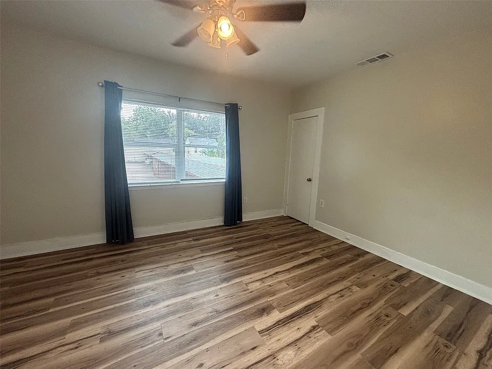 Wood-finish flooring throughout, complemented by a ceiling fan with integrated lighting