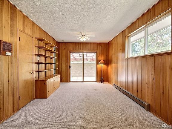 Family room featuring knotty pine paneling w/slider opening onto covered patio for year 'round enjoyment.