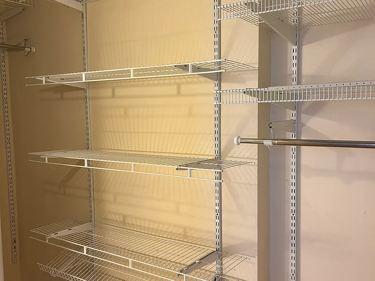 Large closet with shelving and room to hang clothes.