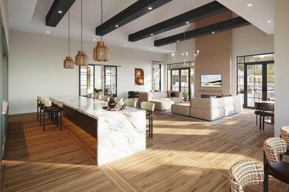 Expansive clubroom with gathering space, catering kitchen, indoor/outdoor fireplace, and lounge seating near Boston, MA.