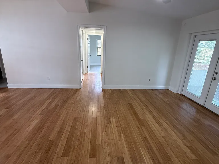 View from primary across living space to hallway to other two bedrooms and bath