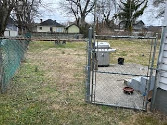 Fenced back yard, concrete patio with gas grill.