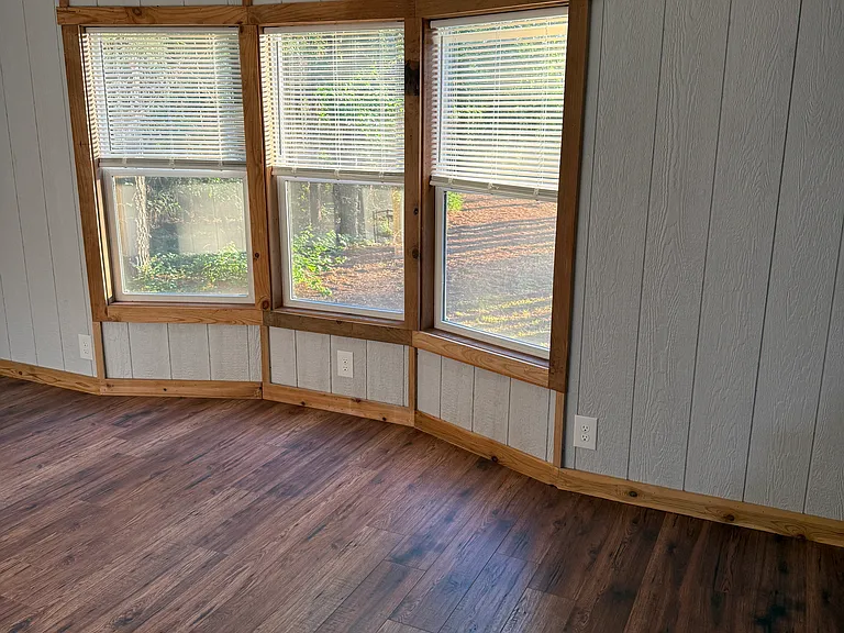 Bedroom 3 with bay window viewing the front yard, its own mini split HVAC and lighted closet.